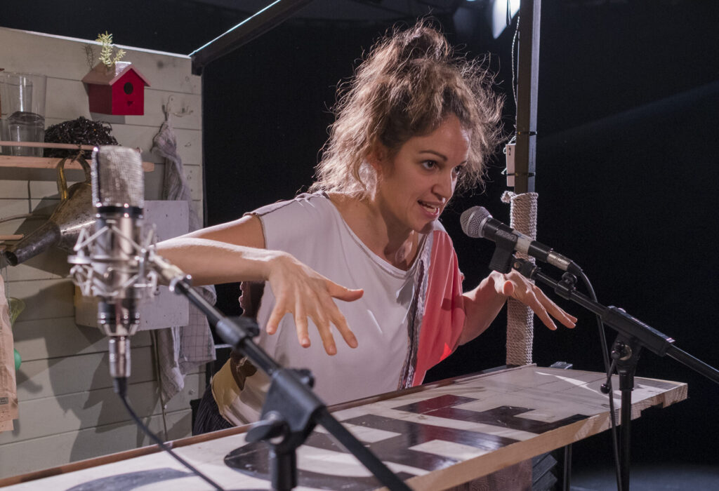 © Foto: Rainer Berson Frau steht vor Mikro und hält Arme hoch.