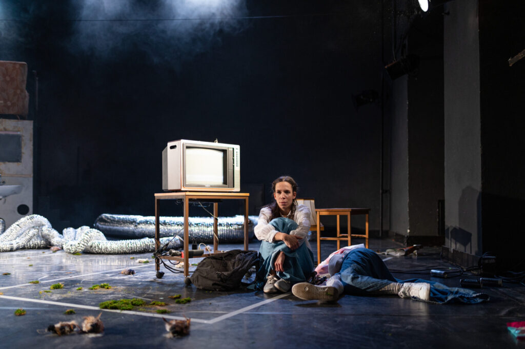 © Foto: Karin Gruber Frau sitzt vor Fernseher, Mädchen liegt verdeckt daneben.