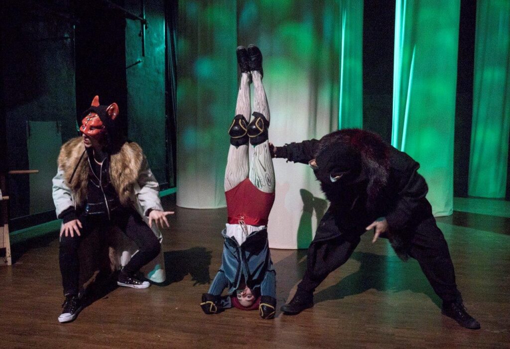 Pinocchio macht einen Kopfstand und wird von Fuchs und Kater begutachtet