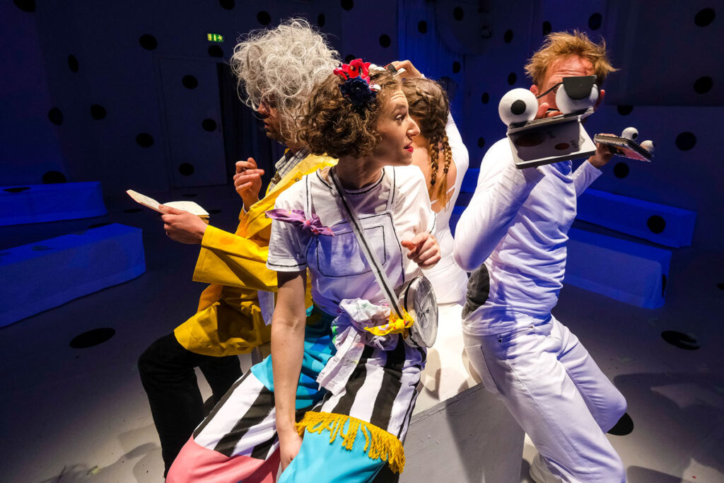 © Foto: Rainer Berson Vier Personen sitzen auf einem Würfel.