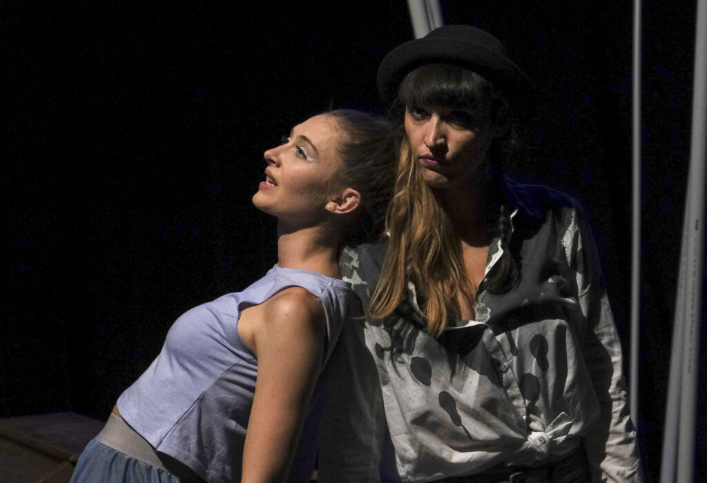 Eine feminine Frau lehnt sich an eine maskulin posierende Frau