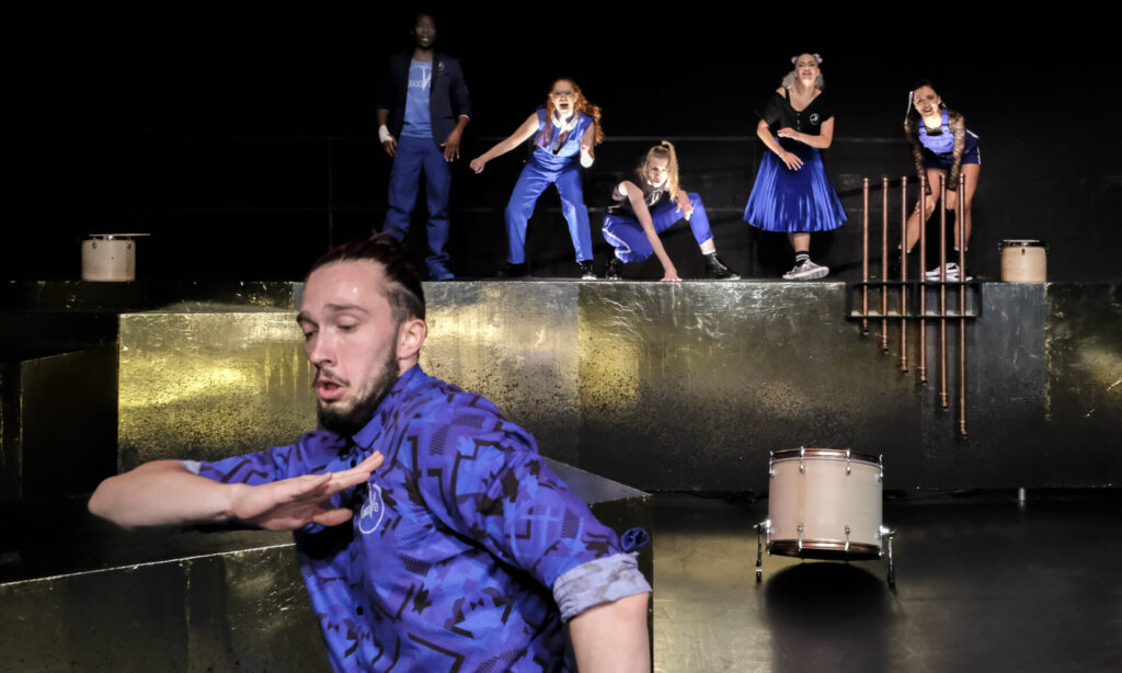 © Foto: Rainer Berson Dynamische Bühnensituation mit blauen Kostümen auf goldener Bühne