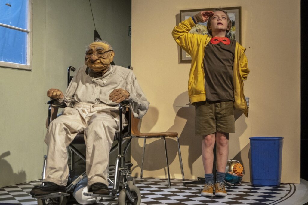 © Foto: Rainer Berson Junge salutiert neben der Puppe eines alten Mannes.