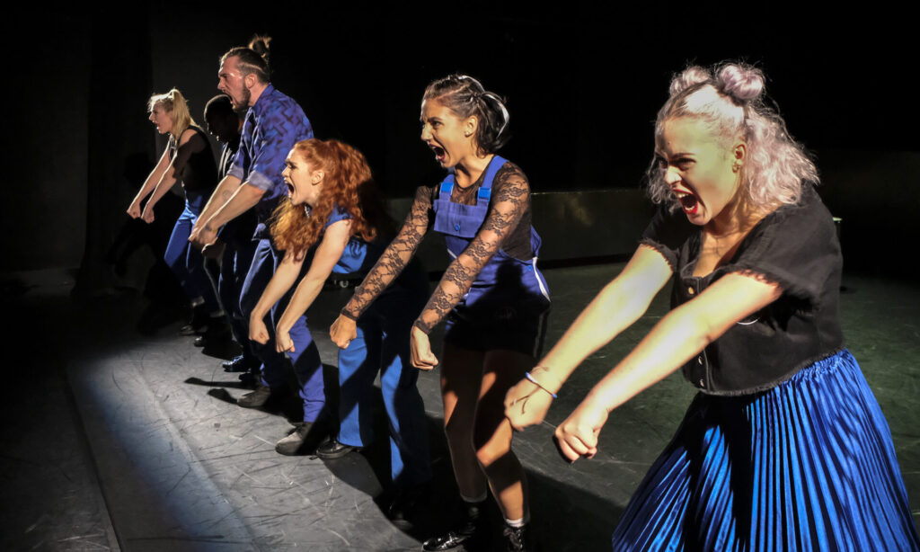 © Foto: Rainer Berson Sechs Performer:innen schreien und strecken ihre Fäuste nach vorne