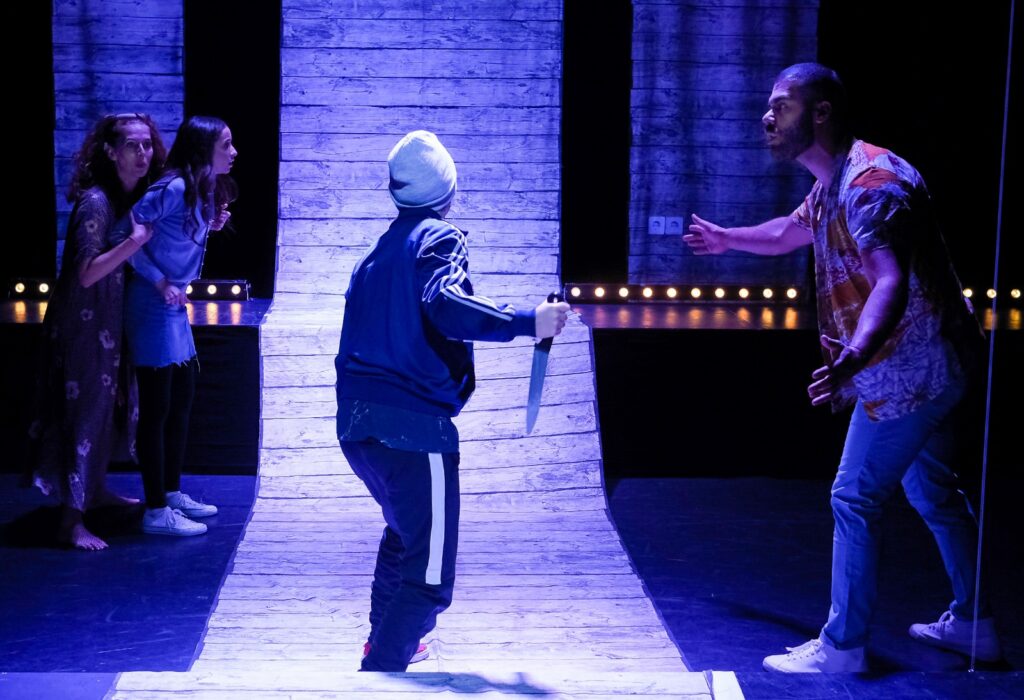 © Foto: Rainer Berson Junge Frau in bedrohlicher Pose mit Messer in der Hand.